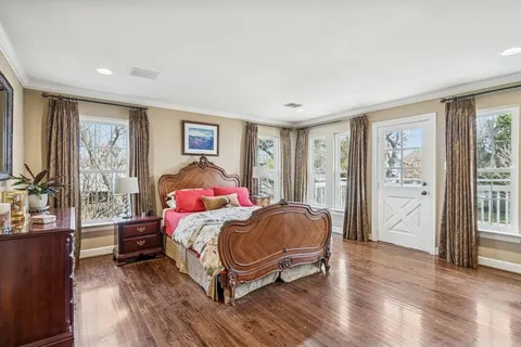 a bedroom with a bed and a large window