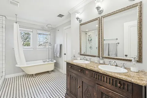 a bathroom with a granite countertop sink a toilet a mirror and shower