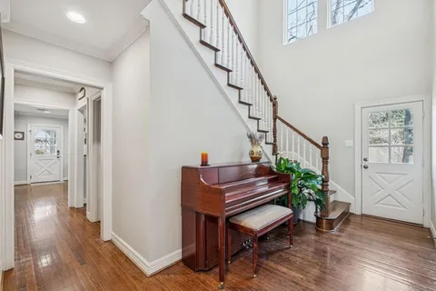a room with wooden floor stairs and windows