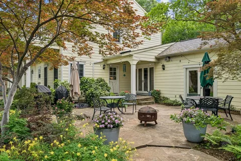 a front view of a house with sitting area and potted plants
