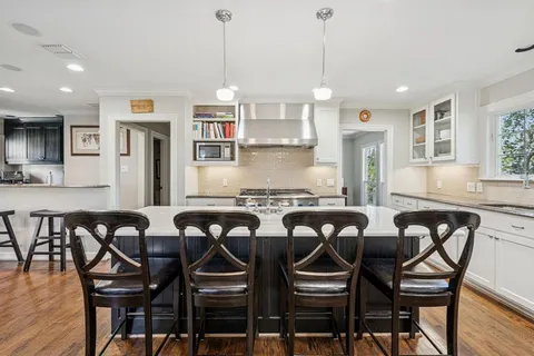 a kitchen with a dining table chairs cabinets and stainless steel appliances