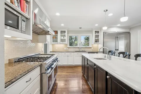 a kitchen with stainless steel appliances granite countertop a sink stove and cabinets