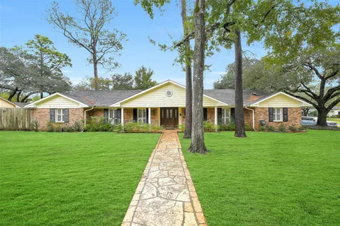 a front view of a house with yard and tree