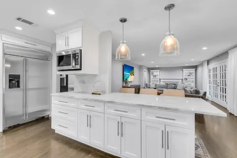 a large white kitchen with stainless steel appliances and white cabinets