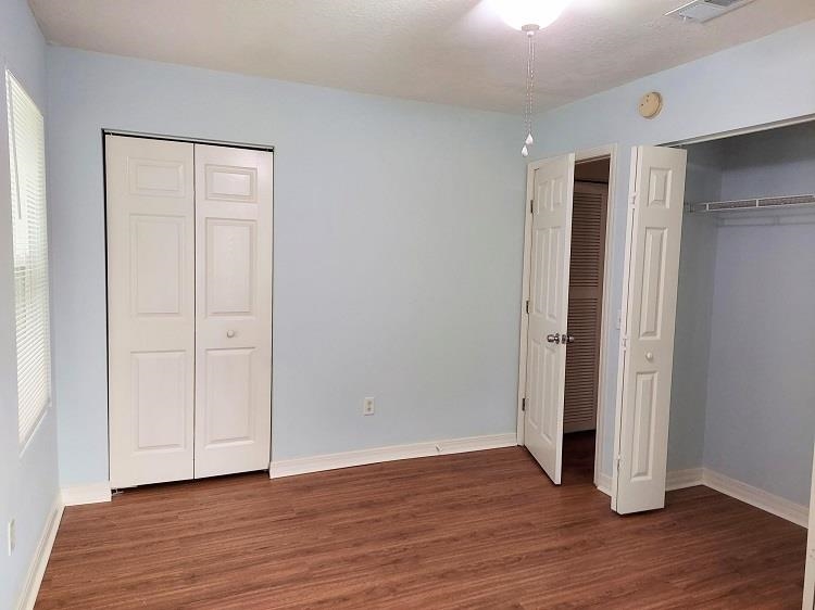 63 Anderson Street St. Augustine, FL 32084 - Photo 13 of 16 Unfurnished bedroom with multiple closets and dark wood-style flooring