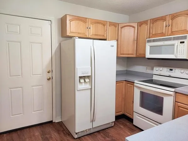 a kitchen with granite countertop white cabinets and white appliances