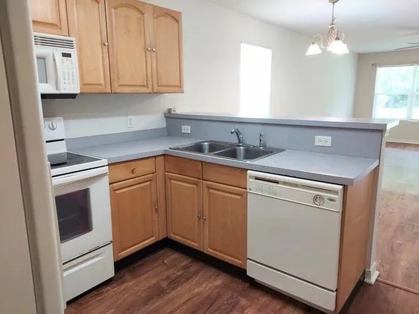a kitchen with a sink cabinets and wooden floor