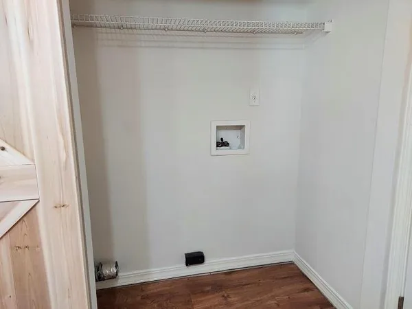a view of a small space with wooden floor and a window