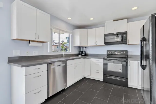 a kitchen with stainless steel appliances granite countertop a refrigerator sink and microwave