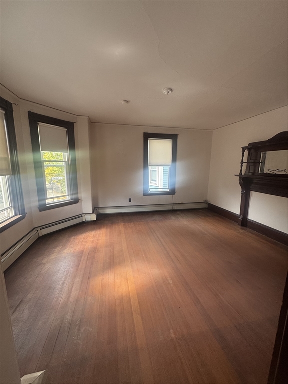 86 Chestnut Street, Unit 2 Brookline, MA 02445 - Photo 2 of 11 an empty room with a hardwood and windows