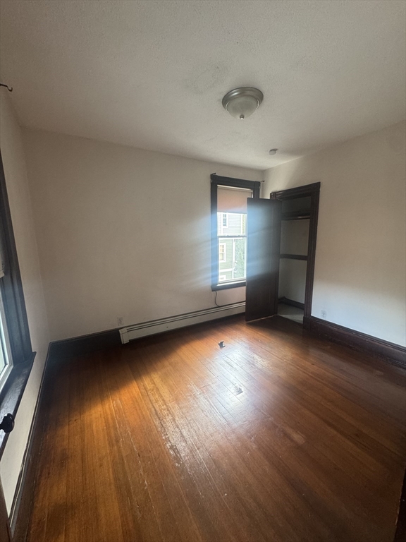 86 Chestnut Street, Unit 2 Brookline, MA 02445 - Photo 3 of 11 an empty room with wooden floor and windows