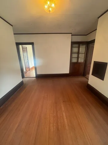a view of a room with wooden floor and white walls