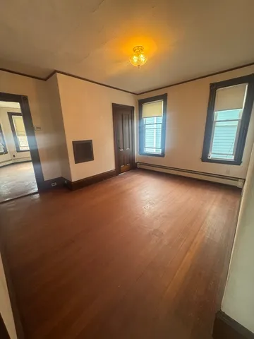 a view of a livingroom with wooden floor and window