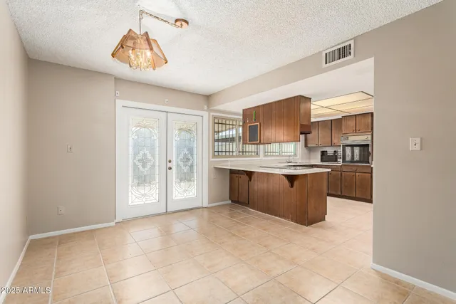 a large kitchen with a stove a sink a counter top space and cabinets