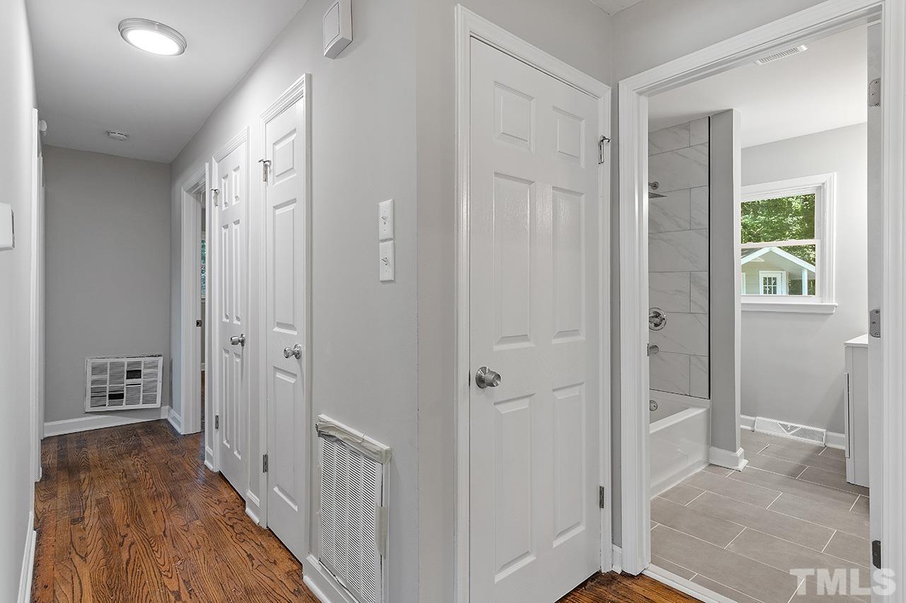1307 Castlebay Road Durham, NC 27704 - Photo 29 of 41 a view of a hallway with wooden floor and a bathroom