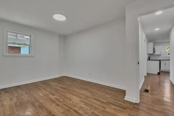 a view of empty room with wooden floor and sink