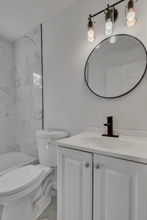 a bathroom with a sink a toilet and a mirror