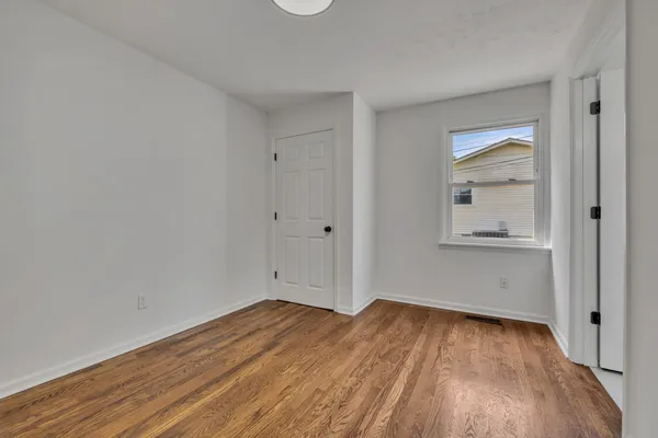 a view of empty room with wooden floor