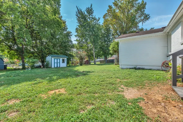 a view of a house with backyard and trees