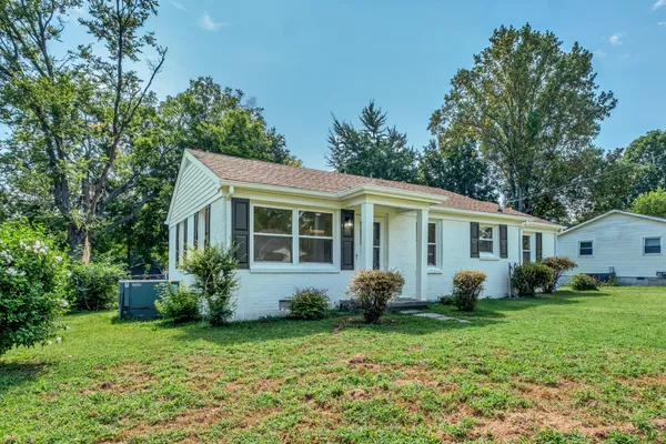 a view of a house with backyard sitting area and garden