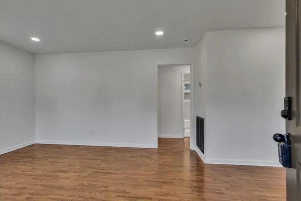 a view of empty room with wooden floor
