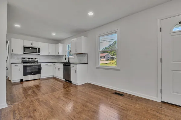a kitchen with stainless steel appliances granite countertop a refrigerator sink and stove