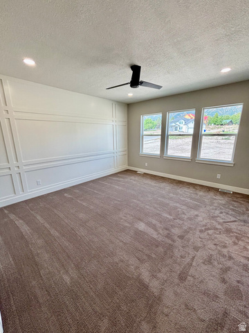 1184 West 3250 North Ogden, UT 84414 - Photo 26 of 69 Master bedroom featuring broadloom carpet, an accent wall with decorative trim, and a modern black ceiling fan