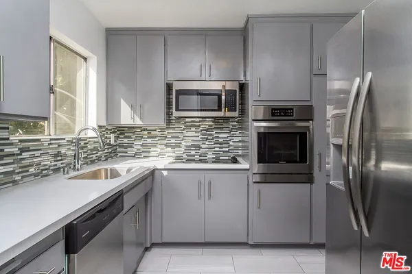 a kitchen with a sink and stainless steel appliances