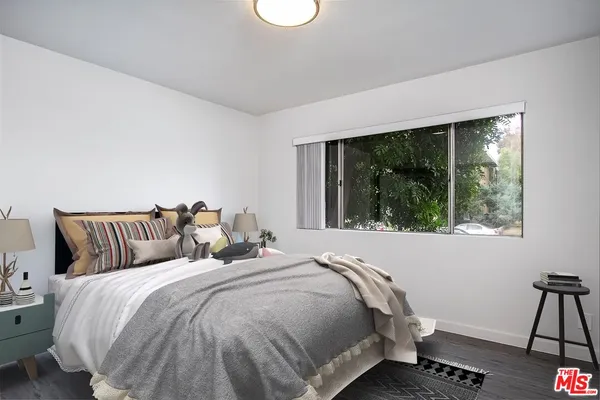 a bed sitting in a bedroom next to a window