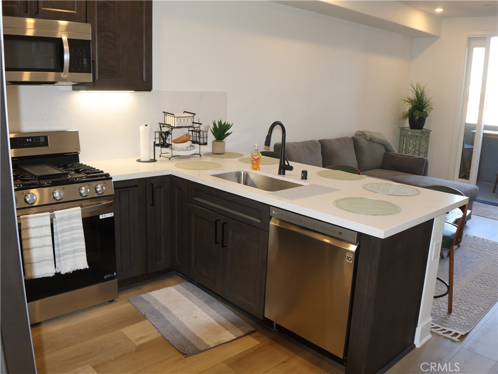 402 West Grand Avenue, Unit 302 Grover Beach, CA 93433 - Photo 2 of 10 a kitchen with a sink cabinets and wooden floor
