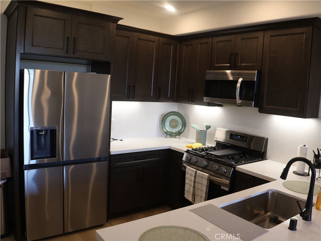 402 West Grand Avenue, Unit 302 Grover Beach, CA 93433 - Photo 3 of 10 a kitchen with appliances a refrigerator and cabinets