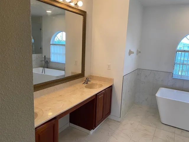 a bathroom with a granite countertop sink and a mirror
