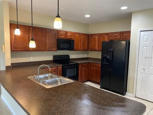 a kitchen with stainless steel appliances granite countertop a sink refrigerator and microwave