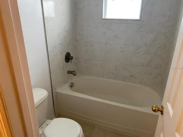 a white bath tub sitting next to a toilet