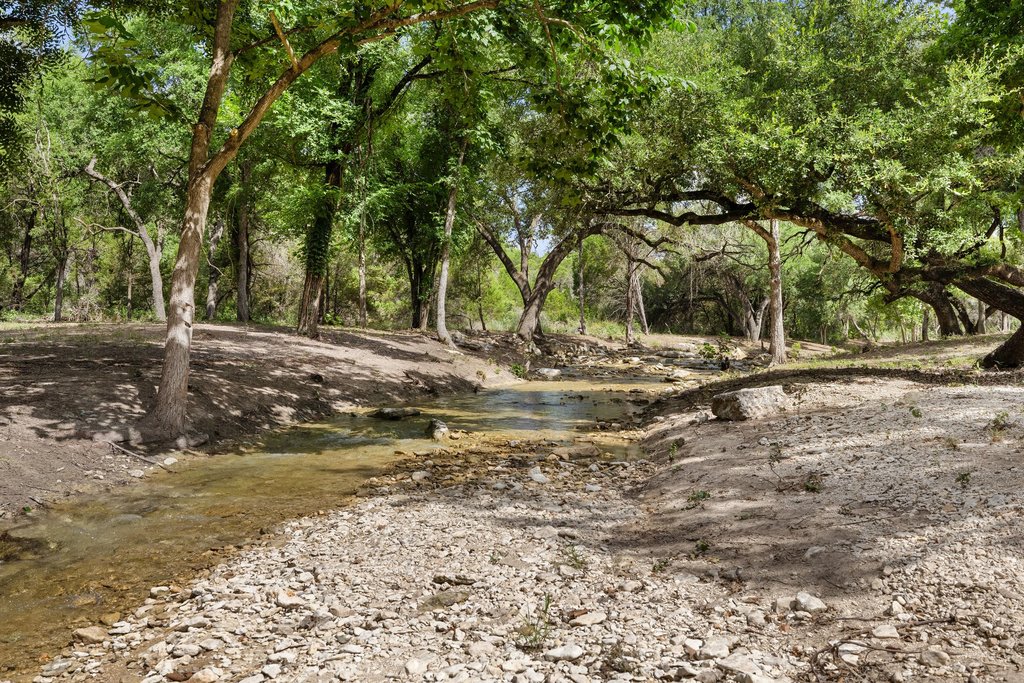 23644 Nameless Road Leander, TX 78641 - Photo 27 of 40 Discover a tranquil stream meandering through a wooded property.