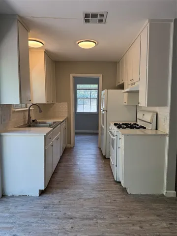 a kitchen with sink cabinets and wooden floor
