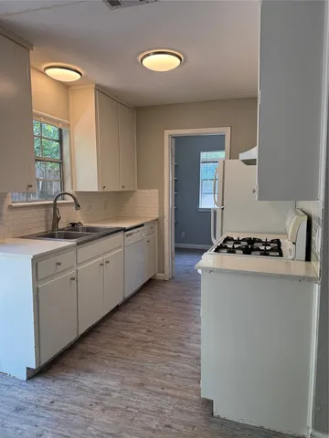 a kitchen with sink stove and cabinets