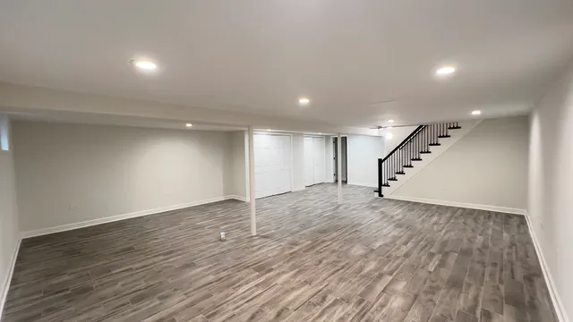 an empty room with wooden floor and stairs