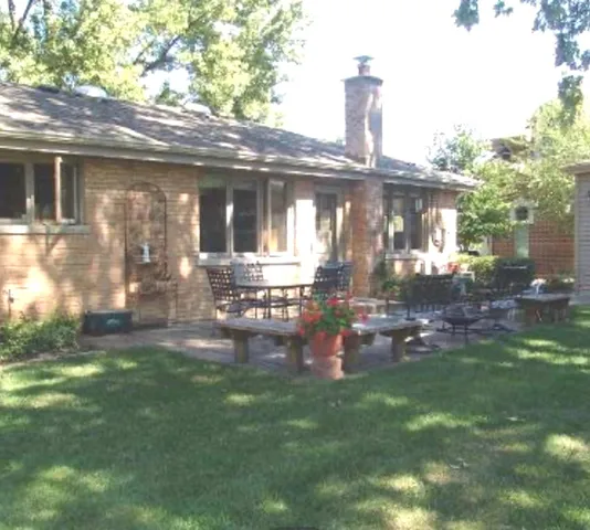 a front view of a house with a yard table and chairs
