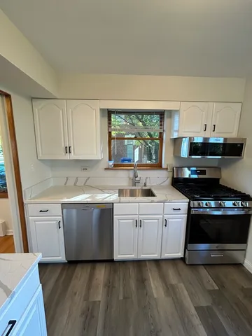 a kitchen with granite countertop white cabinets and appliances