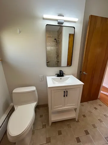 a bathroom with a toilet sink and mirror