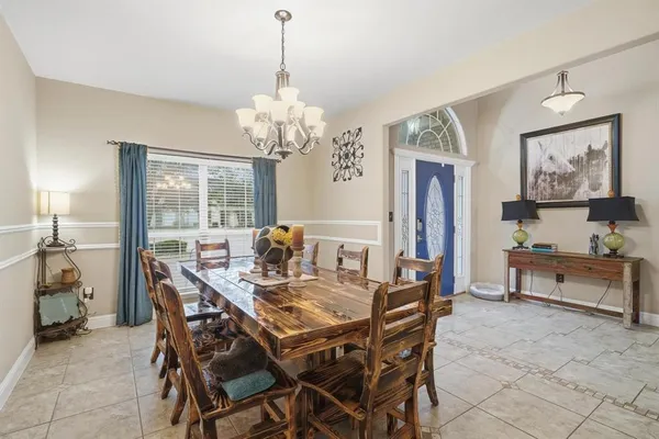 a view of a dining room with furniture a chandelier and window
