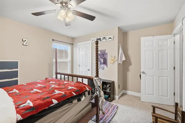 a bed sitting in a bedroom next to a window and a chandelier