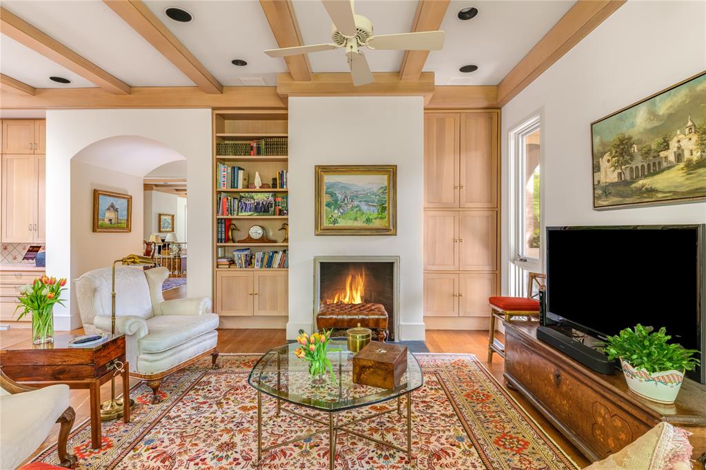 12102 Vendome Place Dallas, TX 75230 - Photo 16 of 24 a living room with furniture a flat screen tv and a fireplace