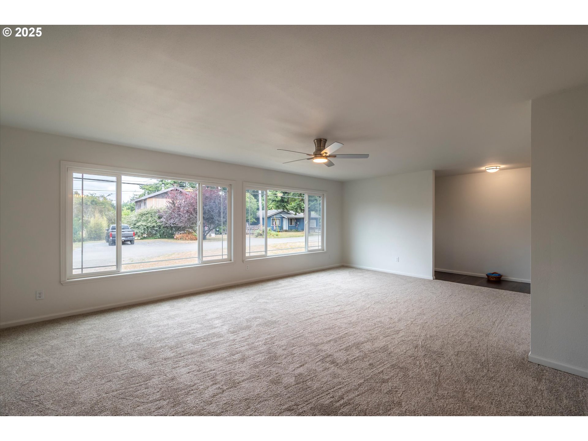 950 1st Street Northeast Bandon, OR 97411 - Photo 15 of 35 a view of a big room with windows and chandelier fan