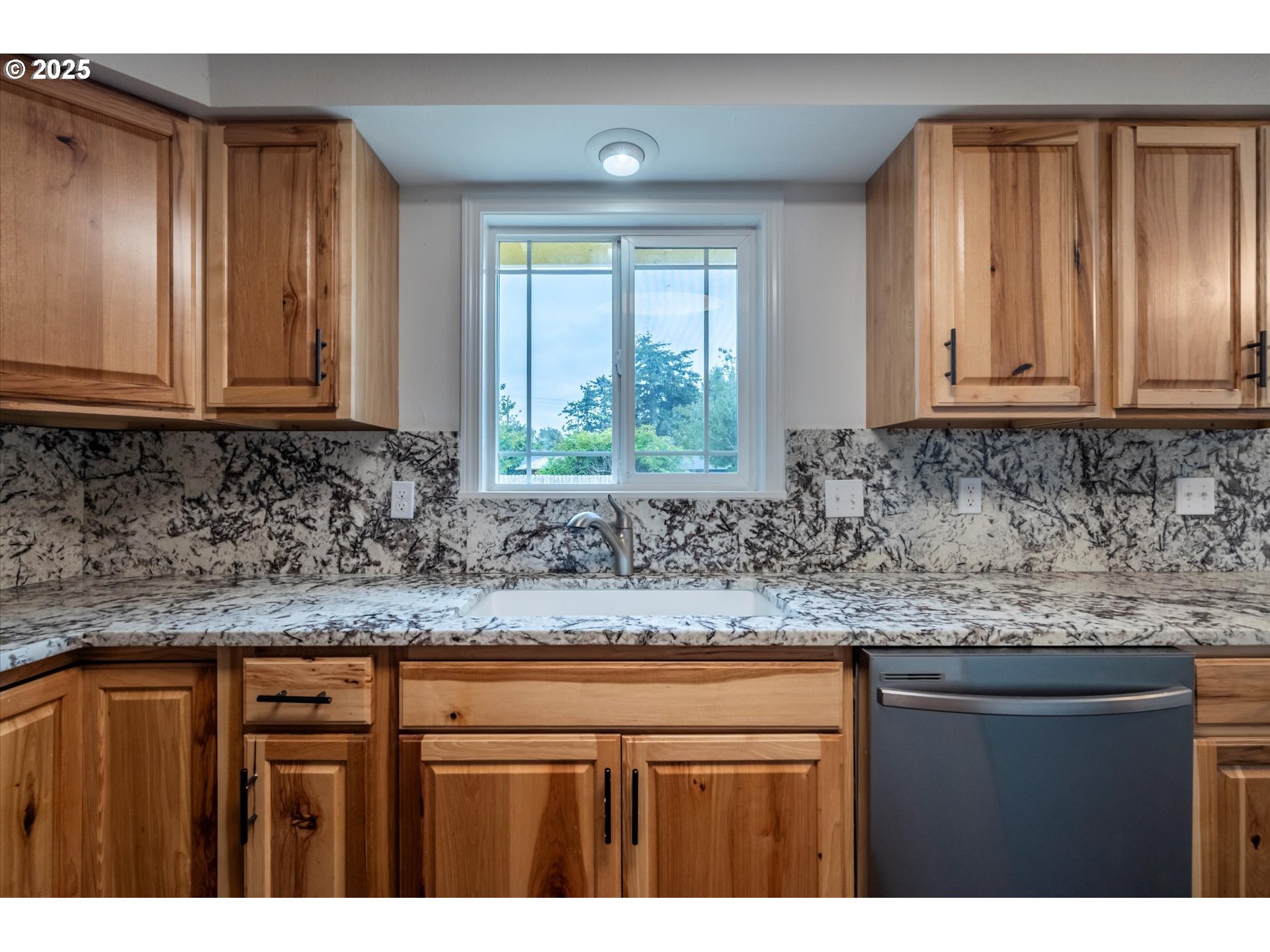 950 1st Street Northeast Bandon, OR 97411 - Photo 19 of 35 a kitchen with granite countertop cabinets and window