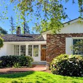 a front view of a house with a yard and fountain