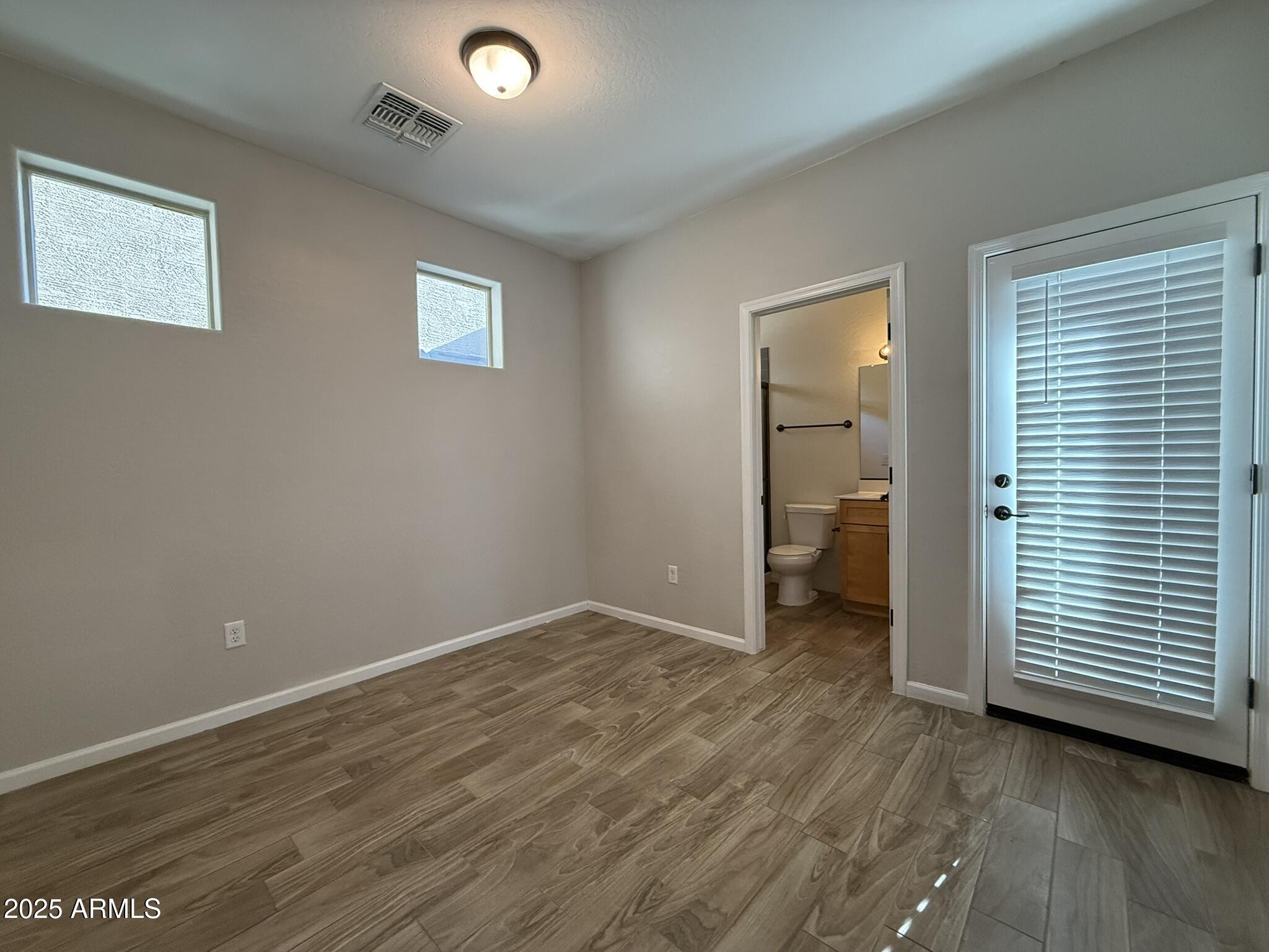 1736 West Pollack Street Phoenix, AZ 85041 - Photo 16 of 51 an empty room with wooden floor and windows