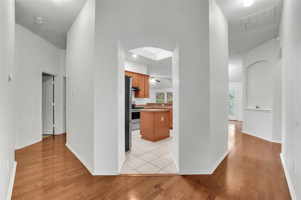 4507 Stones River Road Grand Prairie, TX 75052 - Photo 13 of 28 a view of a hallway with wooden floor and a bathroom