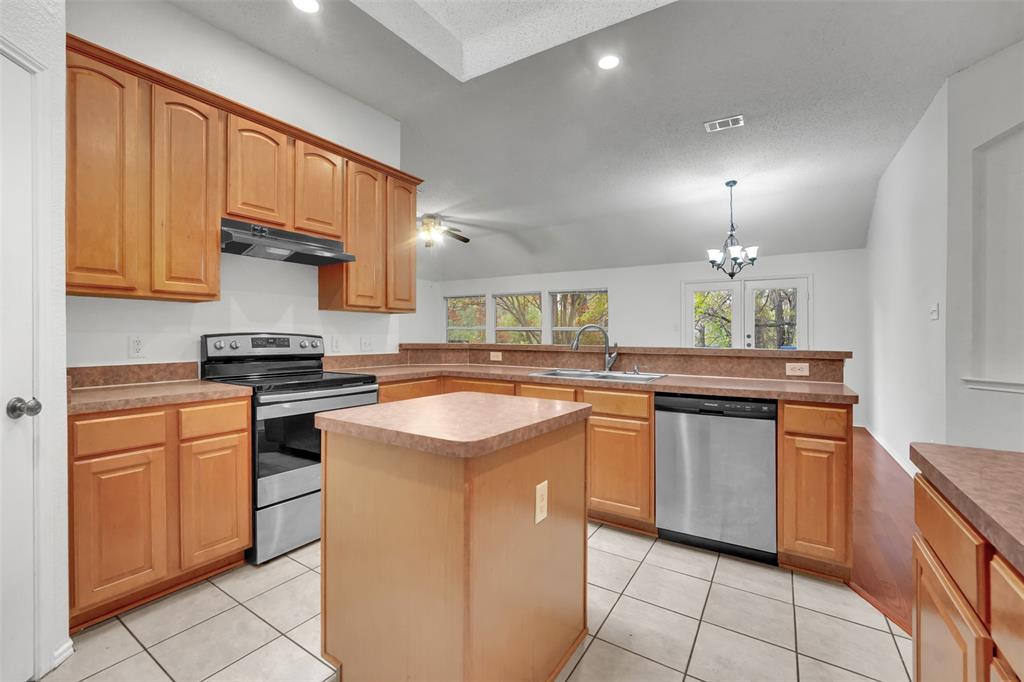 4507 Stones River Road Grand Prairie, TX 75052 - Photo 15 of 28 a kitchen with stainless steel appliances granite countertop a stove a sink and a microwave